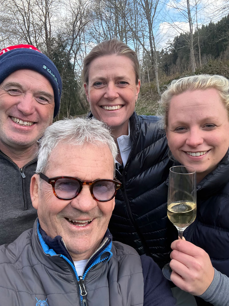 Vier glückliche Menschen auf dem Golfplatz mit einem Glas Sekt
